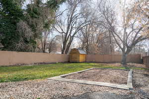 Fenced backyard with a storage unit