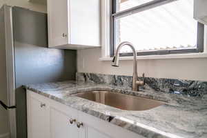 Kitchen with white cabinets and light stone countertops