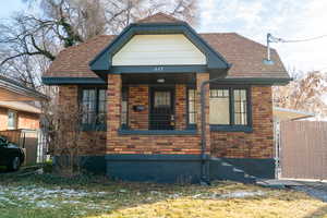 View of front facade featuring brick siding and a shingled roof