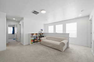 Bedroom featuring recessed lighting, light carpet, and a textured ceiling
