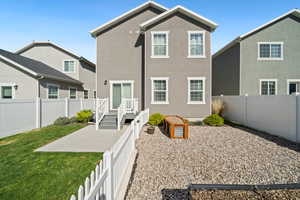 Rear view of property featuring a fenced backyard and stucco siding