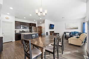 Dining space with dark wood-style flooring, a chandelier, and recessed lighting