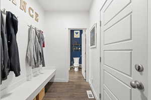 Mudroom with dark wood finished floors and baseboards