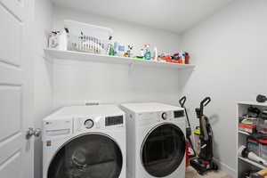 Washroom with washer and clothes dryer and baseboards