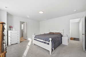 Bedroom featuring light carpet