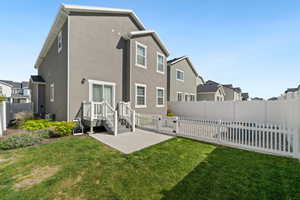 Back of house featuring a fenced backyard, stucco siding, a patio area, and a residential view