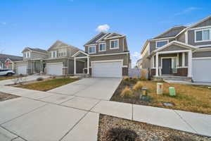 Craftsman-style home featuring board and batten siding, concrete driveway, brick siding, and an attached garage