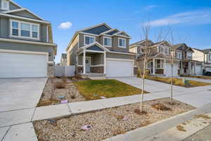 Craftsman-style home with an attached garage, driveway, brick siding, a residential view, and stucco siding