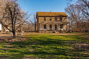 View of front of home with covered porch and a front lawn