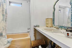 Bathroom with shower / bath combo with shower curtain and vanity