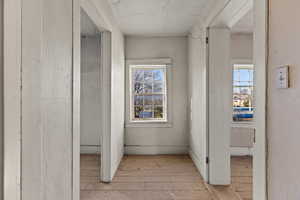 Corridor featuring light wood finished floors