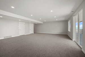 Carpeted spare room with baseboards and recessed lighting