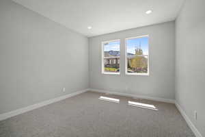 Carpeted empty room with baseboards and recessed lighting