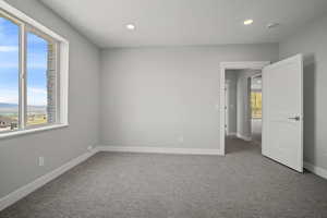 Spare room featuring light colored carpet and recessed lighting