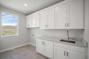 Washroom with cabinet space, hookup for a washing machine, and recessed lighting