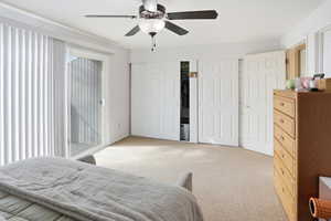 Bedroom with light colored carpet and a ceiling fan