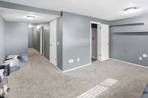 Unfurnished bedroom with carpet floors and baseboards