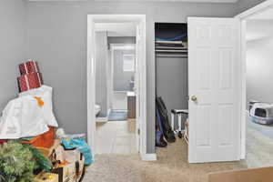 Bedroom featuring light carpet and connected bathroom