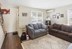 Living room featuring hardwood / wood-style floors and a wall mounted AC