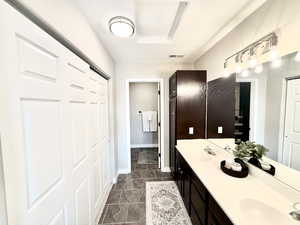 Bathroom with double vanity and baseboards