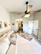 Carpeted bedroom featuring ceiling fan and connected bathroom