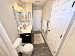 Bathroom with vanity and dark tile patterned floors