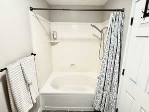 Bathroom featuring shower / tub combo with curtain