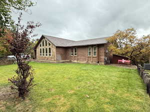 Rear view of property featuring brick siding and roof with shingles