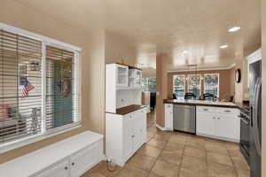 Kitchen featuring white cabinetry, stainless steel appliances, recessed lighting, open shelves, and hanging light fixtures