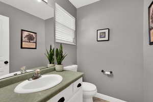 Half bathroom with vanity and toilet