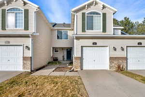 Traditional-style house with a garage, brick siding, and concrete driveway