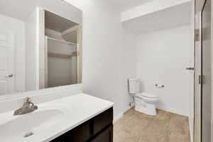 Full bathroom featuring vanity, a stall shower, and light tile patterned floors