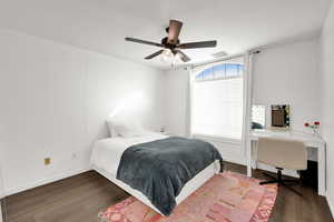 Bedroom featuring wood finished floors, a ceiling fan, and an office area