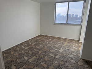 Carpeted room featuring a skyline view