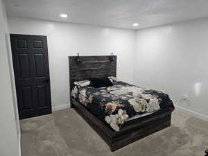 Bedroom featuring carpet flooring, recessed lighting, and a textured ceiling