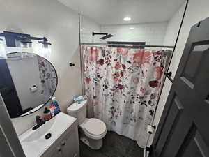 Full bath with curtained shower and vanity