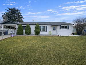 Single story home featuring an attached carport, driveway, and roof with shingles