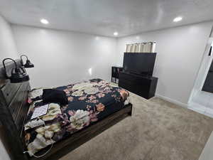 Bedroom with carpet flooring, a textured ceiling, and recessed lighting