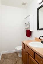 Half bathroom featuring vanity and toilet.