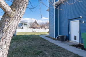 View of north side of the house with newer siding, garage side door, and a large yard.