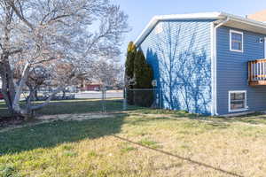 View of south side of the house with newer siding, and a large yard.