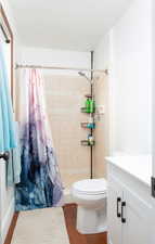 3/4 ensuite primary bathroom with vanity, dark wood-type flooring, and modern backsplash.
