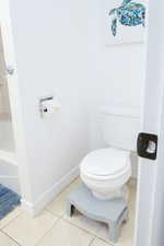 Full bathroom featuring shower / tub combo with curtain, vanity, and light tile patterned floors.