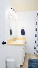 Full bathroom featuring shower / tub combo with curtain, vanity, and light tile patterned floors.