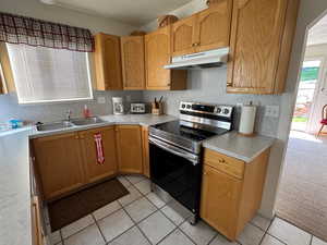 Kitchen featuring stainless steel electric stove and south kitchen window