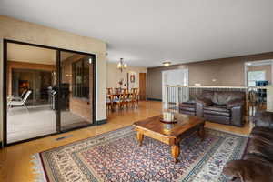 Living area featuring light wood finished floors and a chandelier