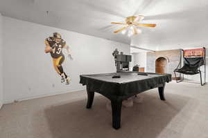 Recreation room featuring billiards, light carpet, a textured ceiling, a fireplace, and a ceiling fan