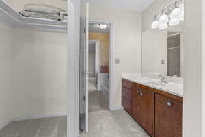 Full bathroom with vanity, light colored carpet, and a bath