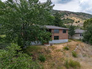 View of side of property featuring brick siding and a patio area