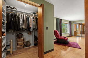 Walk in closet with light wood-style flooring